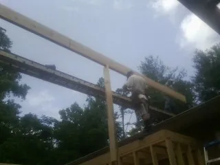 Carpenter setting a ridge beam over a new addition frame — Ice Dam Removal by Roofing Brothers in East Orleans