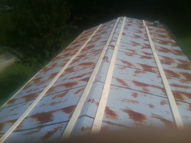 Rusted metal roof panels with new wood purlins before replacement — Storm Damage Roof Repair in East Orleans by Roofing Brothers