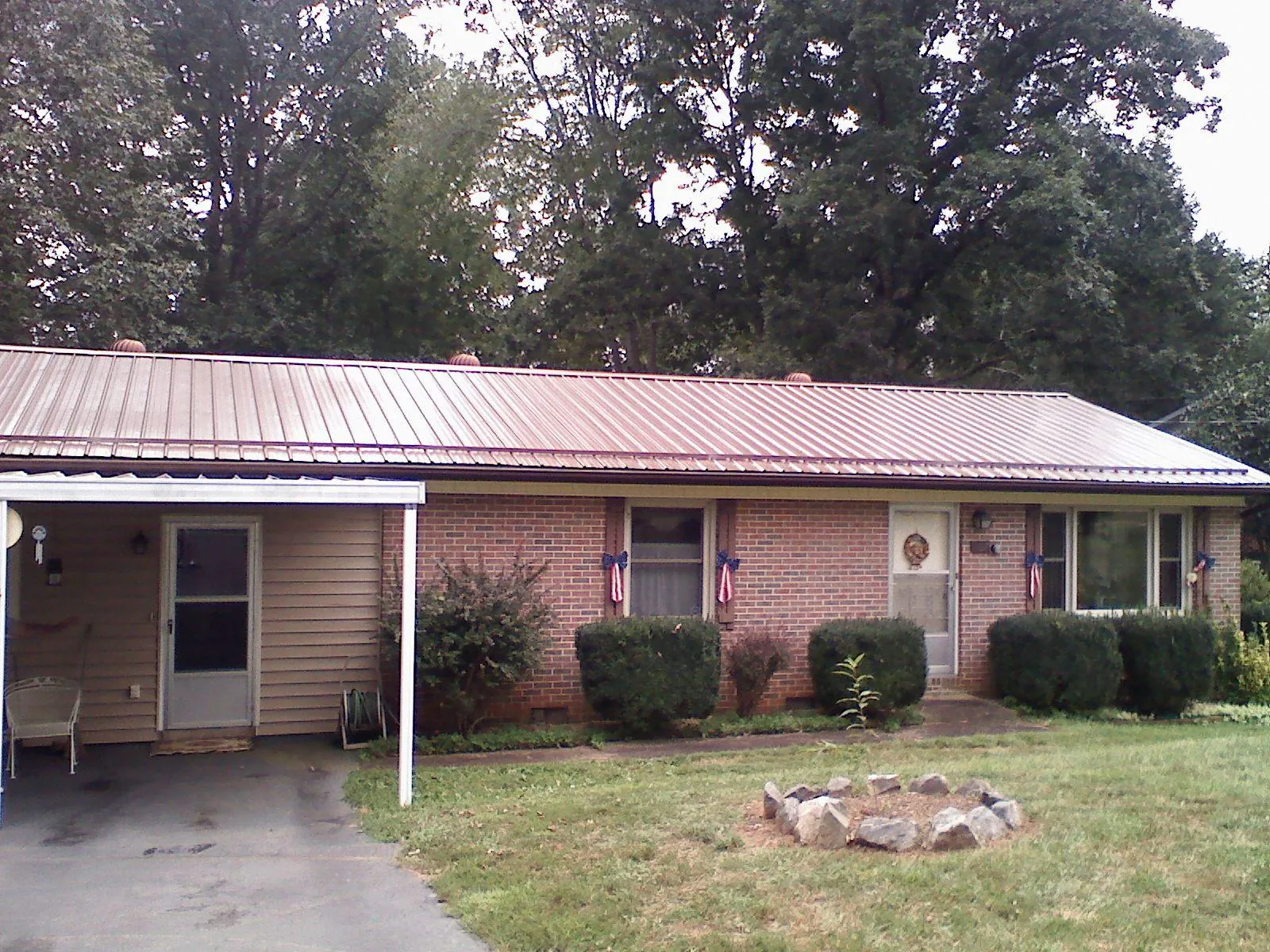 Bronze metal roof and carport on a brick ranch home — Roof Repair work by our crew in East Orleans